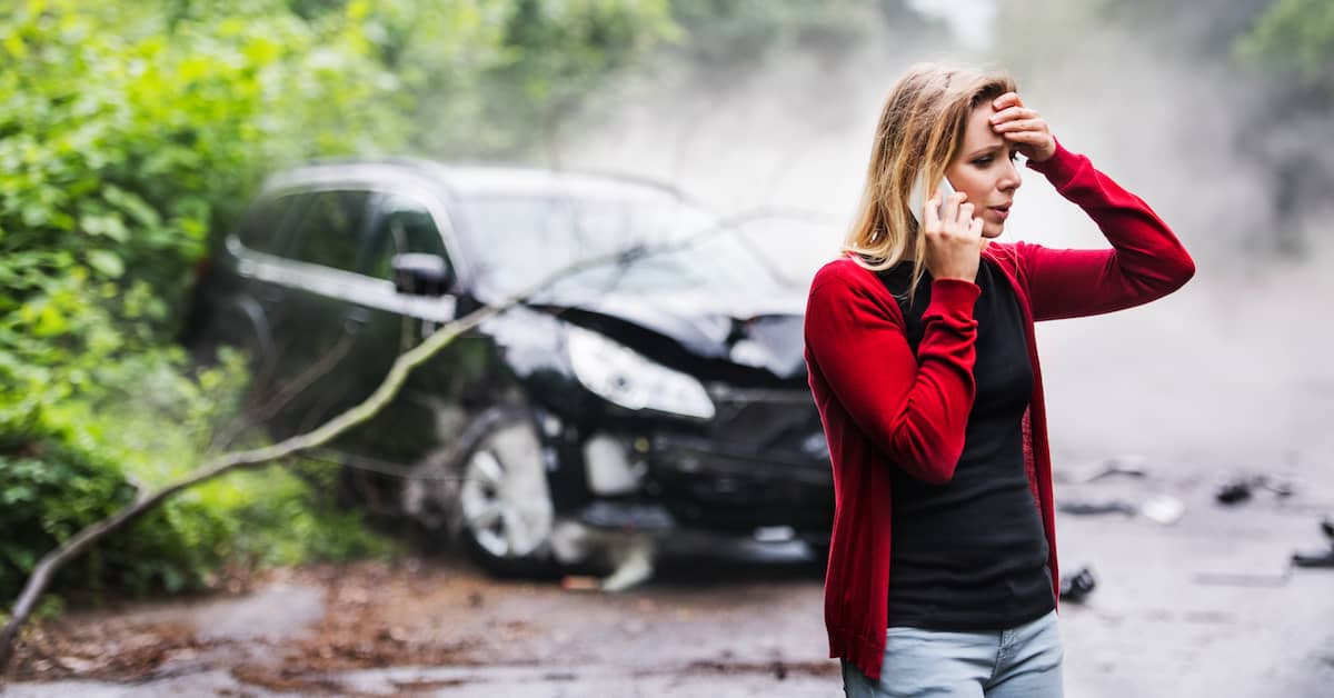 Woman on phone in front of a crashed car. | Colling Gilbert Wright