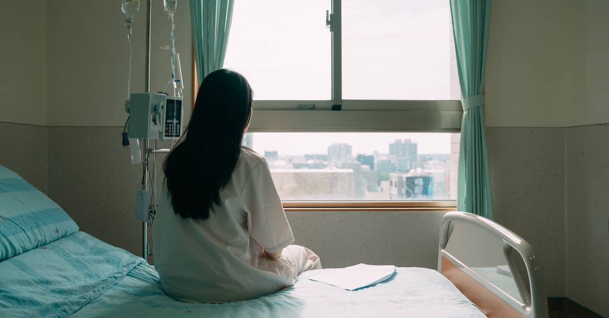 Woman suffering after a diagnostic error looks out window. | Colling Gilbert Wright