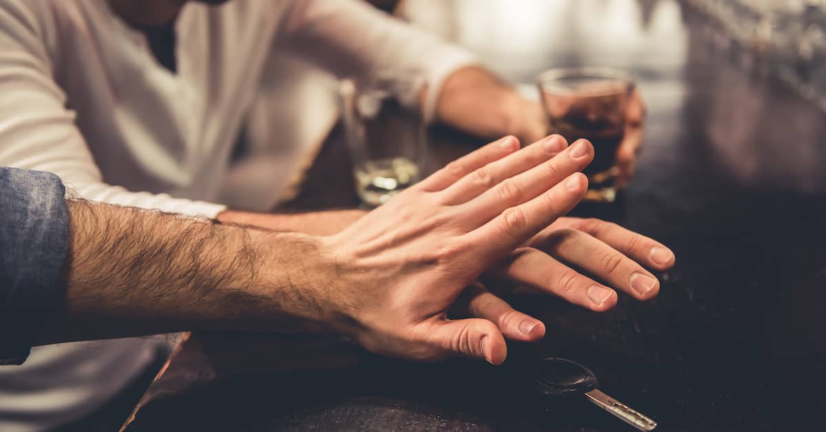 A person reaching for car keys after drinking and a friend stopping them. | Colling Gilbert Wright