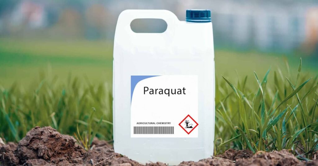 Plastic bottle of paraquat herbicide in field. | Colling Gilbert Wright