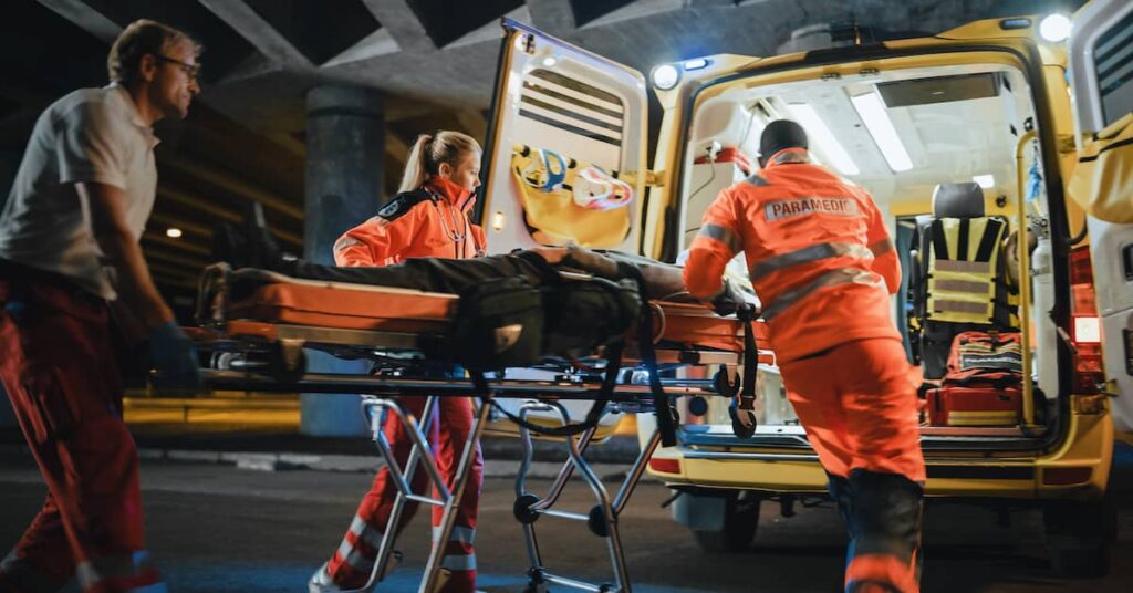 Paramedics put seriously injured person in ambulance. | Colling Gilbert Wright