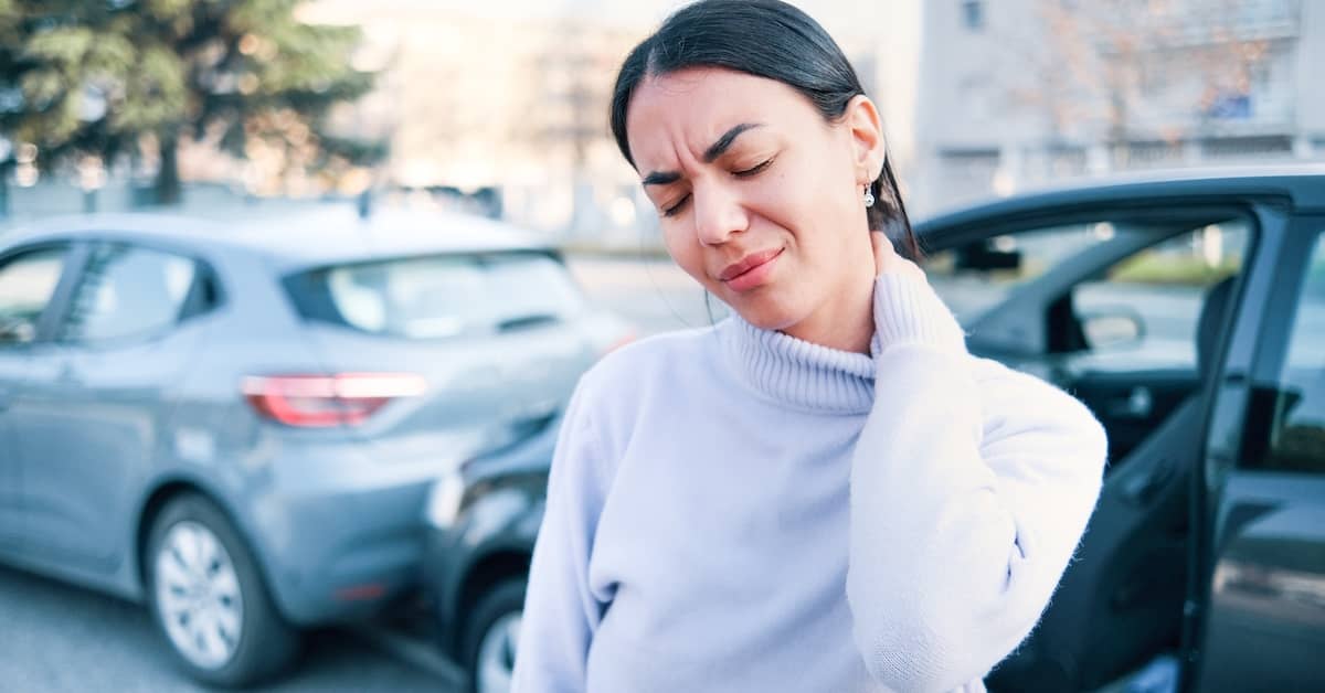 Woman rubs neck after car accident. | Colling Gilbert Wright